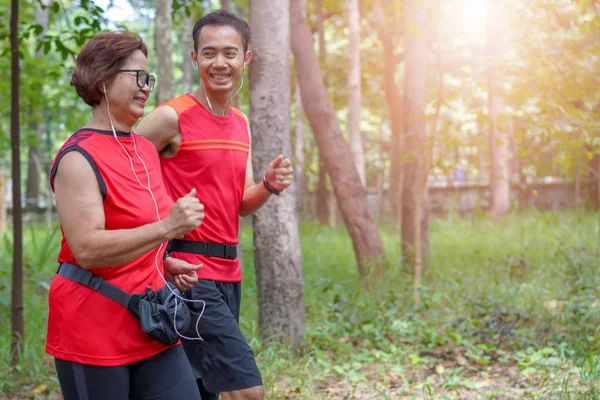 男やジョギング公園 高齢者介護運動スポーツ活動コンセプトでランニングのパーソナル トレーナーと幸せの上級アジアの女性 — ストック写真