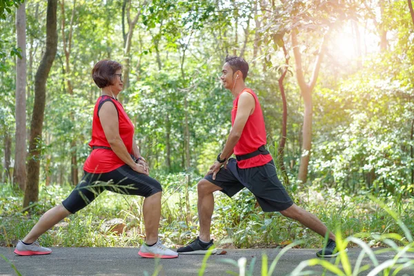 アジアの母と息子に合うランナー公園 高齢者介護運動スポーツ活動コンセプトで実行する前にストレッチ — ストック写真