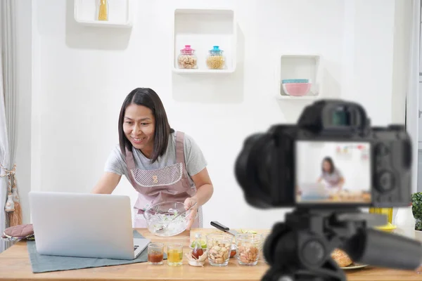 Женщина приготовления пищи с квитанцией на ноутбуке компьютер на кухне, Wi — стоковое фото