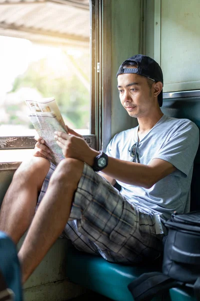 Asiatique homme voyage routard lecture carte assis sur le vieux train — Photo