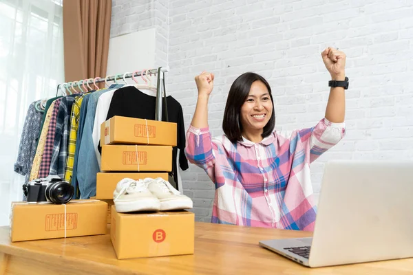 アジアの女性は、新しい注文の後にオンラインで幸せな販売に成功しました — ストック写真