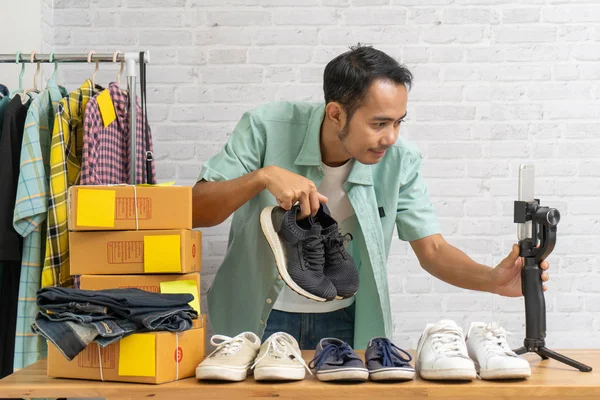 Азіатський чоловік, використовуючи розумний мобільний телефон беручи жити продажу взуття онлайн, запис рішень відео Blogger камери — стокове фото