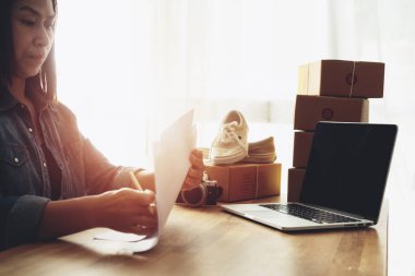 Kadınlar ev ofis masasında konsantre görünümlü belgeler üzerinde çalışan, Online satış