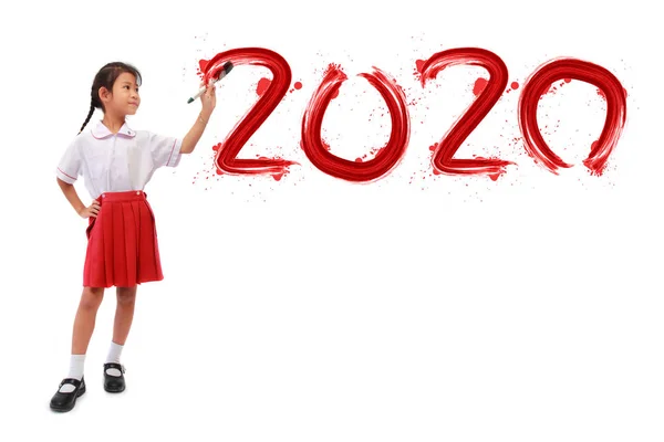 Menina segurando uma pintura pincel pintura feliz ano novo 2020 em uma parede branca — Fotografia de Stock