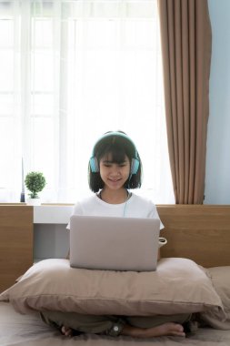 Asyalı kız internette ödev okuyor evde ders veriyor, sosyal uzaklık online eğitim fikri
