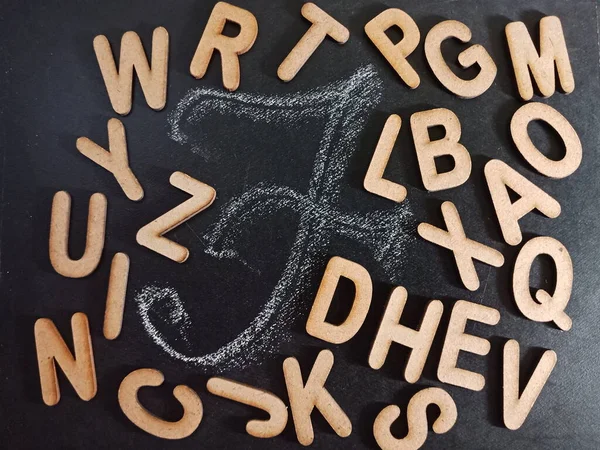 English alphabet letter F displaying with all alphabetic text collection on black board surface hand written and wooden mixed background.