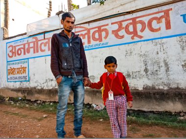 Katni Bölgesi, Madhya Pradesh, Hindistan - 07 Ocak 2020: Hintli bir ilkokul çocuğu ağabeyinin elini tutarak okula gidiyor.