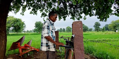 Katni Bölgesi, Madhya Pradesh, Hindistan - 20 Ağustos 2019: Hintli yaşlı bir adam bisikletiyle doğal arka planda bisiklet sürüyor.