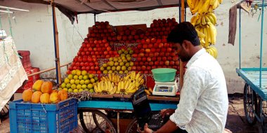 Katni Bölgesi, Madhya Pradesh, Hindistan - 20 Ağustos 2019: Yol kenarında dizüstü bilgisayar teknolojisini öğrenen bir Hint köyü meyve satıcısı.