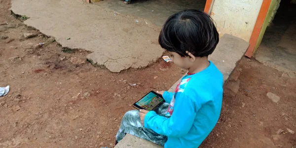 印度中央邦Katni区 2019年8月20日 一名印第安小女孩在智能手机屏幕上观看卡通片 — 图库照片