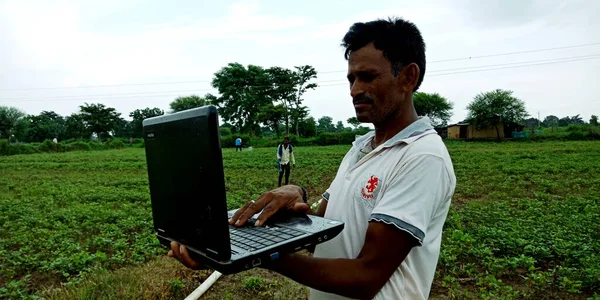 Katni Bölgesi, Madhya Pradesh, Hindistan - 28 Ağustos 2019: Yerli bir adam açık arkaplanda doğal tarım alanı etrafında dizüstü bilgisayar teknolojisini öğreniyor.