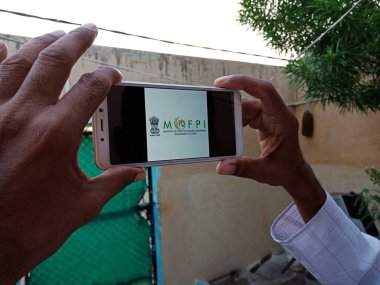 DISTRICT KATNI, INDIA - 23 Mayıs 2020: Hindistan 'ın gıda işleme endüstrisi hükümetinin görüntülenmiş bakanlığı ile akıllı telefon taşıyan adam ekranda. Hükümet iktidar partisi bu politikaya başladı.