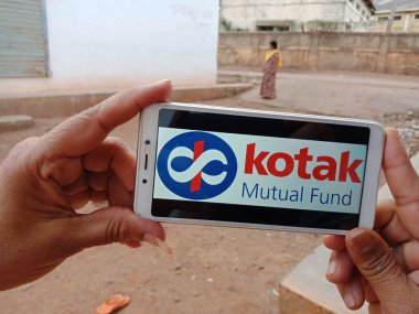 DISTRICT KATNI, INDIA - HAZİRAN 02, 2020: Kotak Mutual Fund logosunu ekranda gösteren akıllı telefon tutan Hintli bir kadın, köy halkı için modern bankacılık eğitimi kavramı.