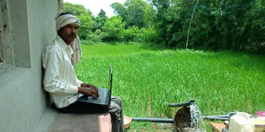 DİSTRİK KATNI, INDIA - 20 AĞUSTOS 2019: Asyalıların dijital öğrenimi için Asya köyü erkek çiftçi dizüstü bilgisayarı konsepti.