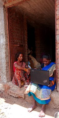 DISTRICT KATNI, INDIA - 20 Ağustos 2019: İki Hintli köy kadını dizüstü bilgisayar teknolojisini birlikte öğreniyor, Asyalı kadınların dijital öğrenme kavramı.