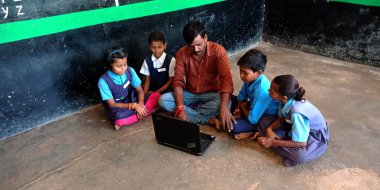DISTRICT KATNI, INDIA - 20 AĞUSTOS 2019: Hindistan devlet okulu öğrencileri sınıfta dizüstü bilgisayar teknolojisini öğreniyor. Erkek öğretmen öğrencilere bilgisayar konseptini açıkladı.