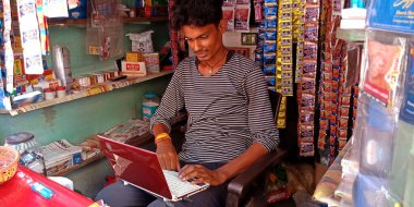 DISTRICT KATNI, INDIA - 08 AĞUSTOS 2019: Dijital teknoloji farkındalık programı öğrenen Hintli bir pan mağaza görevlisi çocuk dizüstü bilgisayar sistemi.