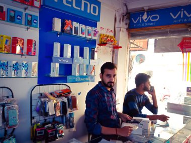 DISTRICT KATNI, INDIA - 17 Ekim 2019: Satış temsilciliği için mobil bir mağazada duran iki satış yöneticisi.