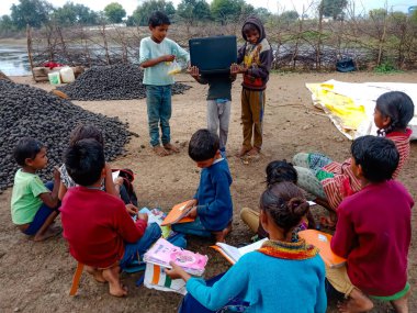 DISTRICT KATNI, INDIA - HAZİRAN 01, 2020: Hindistan köyünün fakir çocukları bir grup çocukla dizüstü bilgisayar teknolojisini öğreniyorlar, dijital teknoloji eğitim farkındalığı kavramı.