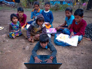 DISTRICT KATNI, INDIA - HAZİRAN 01, 2020: Hindistan köyündeki fakir erkek çocuk bir grup çocukla komik eylemler, dijital teknoloji farkındalığı kavramı.