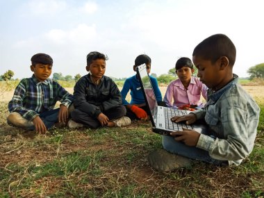 DISTRICT KATNI, INDIA - HAZİRAN 01, 2020: Açık alandaki çocuklara dizüstü bilgisayar teknolojisini öğreten Hintli fakir bir çocuk.