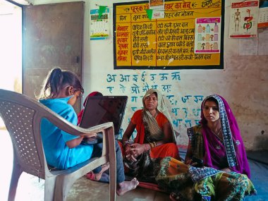 DISTRICT KATNI, INDIA - HAZİRAN 01, 2020: Hintli bir köy kızı Anganwadi Hükümet Merkezi 'ndeki fakir kadına dizüstü bilgisayar teknolojisi hakkında ders veriyor.