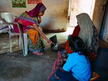 DISTRICT KATNI, INDIA - HAZİRAN 01, 2020: Bir Hint köyü Anganwadi kadın öğretmeni yoksul kadınlara dizüstü bilgisayar teknolojisi hakkında ders veriyor.