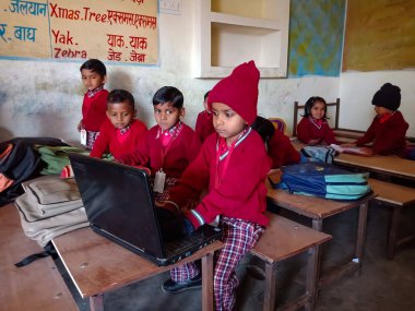DİSTRİK KATNI, INDIA - 13 HAZİRAN 2020: Hintli ilkokul çocuğu sınıfta dizüstü bilgisayar teknolojisini birlikte öğreniyor.