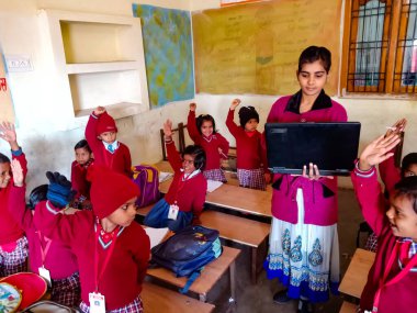 DISTRICT KATNI, INDIA - 13 HAZİRAN 2020: Hindistan ilköğretim okulu bayan bilgisayar öğretmeni sınıftaki öğrencilere laptop teknolojisi hakkında eğitim veriyor.