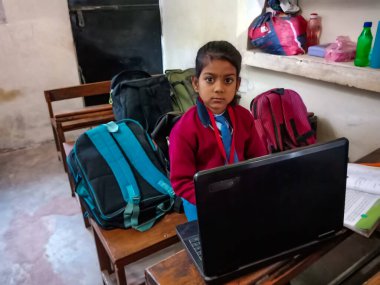DISTRICT KATNI, INDIA - 13 HAZİRAN 2020: Hintli ilkokul öğrencisi sadece bilgisayar teknolojisini sınıf banklarında öğreniyor.