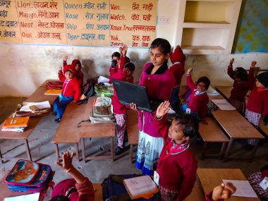 DİSTRİK KATNI, INDIA - 13 HAZİRAN 2020: Hintli ilkokul öğretmeni sınıf öğrencilerine laptop teknolojisi hakkında eğitim veriyor.