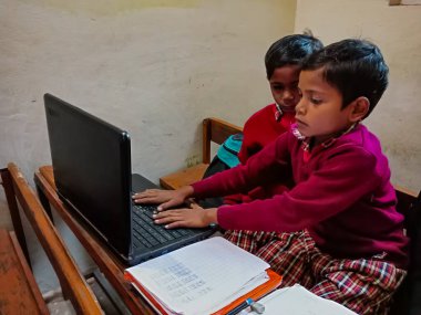 DİSTRİK KATNI, INDIA - 13 HAZİRAN 2020: Hintli ilkokul öğrencileri sınıfta dizüstü bilgisayar teknolojisini birlikte öğreniyorlar.