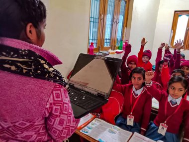 DİSTRİK KATNI, INDIA - 13 HAZİRAN 2020: Hintli ilkokul öğretmeni sınıftaki öğrencilere laptop teknolojisi hakkında eğitim veriyor.
