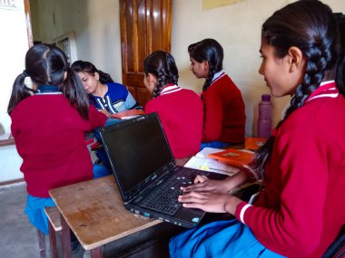 DİSTRİK KATNI, INDIA - 13 Ocak 2020: Hintli ilkokul kızı sınıfta dizüstü bilgisayar teknolojisini tek başına öğreniyor.