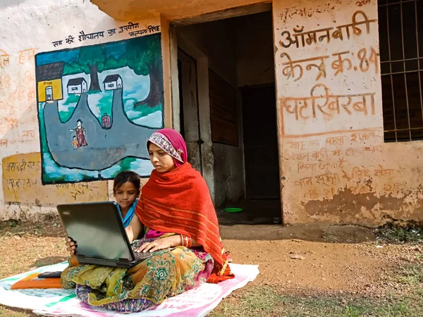 DISTRICT KATNI, INDIA - HAZİRAN 01, 2020: Bir Hint köyü Anganwadi kadın öğretmeni fakir liseli kızlara dizüstü bilgisayar teknolojisi hakkında ders veriyor.