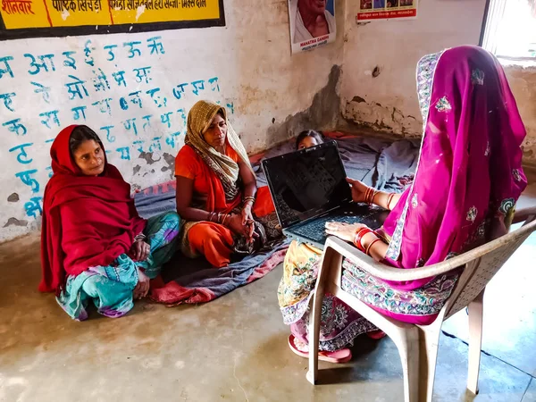 DISTRICT KATNI, INDIA - HAZİRAN 01, 2020: Bir Hint köyü Anganwadi kadın öğretmeni fakir kadınlara dizüstü bilgisayar teknolojisini öğretiyor.