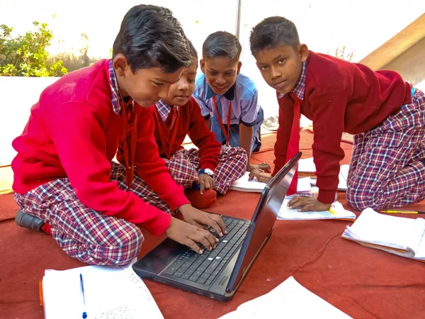 DİSTRİK KATNI, INDIA - 13 HAZİRAN 2020: Hindistan ilkokul öğrencileri açık alanda dizüstü bilgisayar teknolojisini birlikte öğreniyorlar.