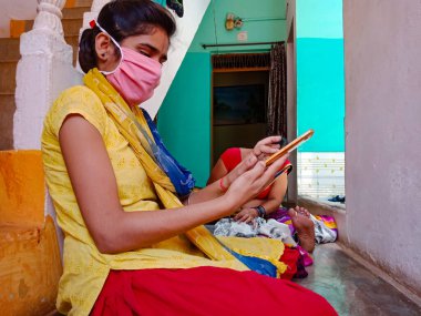 DISTRICT KATNI, INDIA - 21 Mayıs 2020: Evde Coronavirus koruması için yüz maskesi takan Hintli bir kız.
