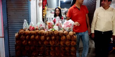 DISTRICT Birsinghpur Pali, INDIA - 22 Temmuz 2019: Hindu dini festivali sırasında tapınak sokağında hindistan cevizi satan bir Hintli kız.