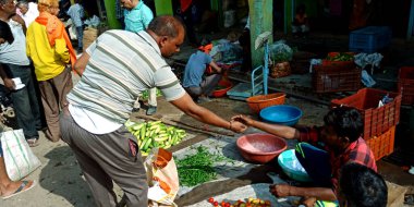 DISTRICT KATNI, INDIA - 07 Ağustos 2019: Asyalı sebze müşterisi açık tarım taze sebze pazarındaki manavlara para veriyor.
