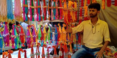 DİSTRİK KATNI, INDIA - 12 Ağustos 2019: Asyalı fakir bir adam Asya caddesi ana pazarında geleneksel Hint rakhi festivali sırasında güzel rakhi satıyor.