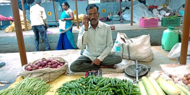 DISTRICT KATNI, INDIA - 14 Ağustos 2019: Hindistan sebze yeşili taze tarım ürünleri pazarında kadın parmağı satan Asya köyü erkek satıcısı.