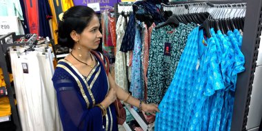 DİSTRİK KATNI, INDIA - 14 Ağustos 2019: Hint geleneksel şehir kadını alışveriş merkezinden modern giysiler alıyor.