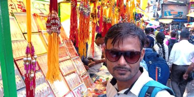 DISTRICT KATNI, INDIA - 14 Ağustos 2019: Asyalı şehir çocuğu Hindu dini festivalinde yerel sokak pazarında Rakhi satın alıyor.