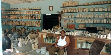 DİSTRİK JABALPUR, INDIA - 17 AĞUSTOS 2019: Narmada River Caddesi 'nde satılık Mermer taş el sanatları heykeli üzerinde oturan olgun bir adam.