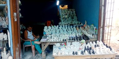 DISTRICT JABALPUR, INDIA - 17 AĞUSTOS 2019: Narmada River Caddesi 'nde misket taş heykel satan Asyalı esnaf.