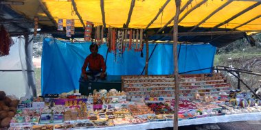 DISTRICT JABALPUR, INDIA - 17 AĞUSTOS 2019: Mermer taş el satan Asyalı esnaf Narmada Nehri caddesi dükkanında yapay mücevherler yaptı.