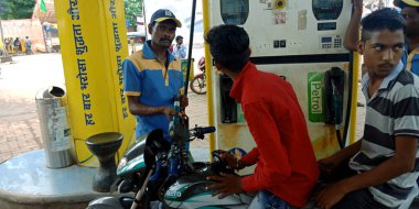 DISTRICT KATNI, INDIA - SEPTEMBER 04, 2019: Hindustan Petrol istasyonunda bisiklet tankında yakıt doldururken benzine bakan Asyalı motosiklet sürücüsü.