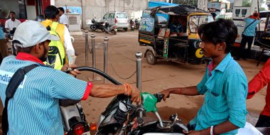 DISTRICT KATNI, INDIA - 23 Ağustos 2019: Asyalı benzin pompası çalışanı Hint benzin istasyonundaki benzin deposunda yakıt doldurmak için başlık tuttu.