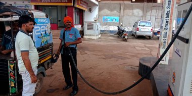 DISTRICT KATNI, INDIA - 23 Ağustos 2019: Asyalı benzin pompacısı erkek Hint petrol istasyonunda kamyon deposunda yakıt dolduruyor.